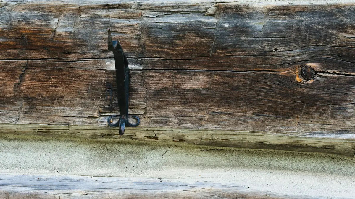 Poutre en bois patinée par les années, encore saine, avec sa ferrure d'origine