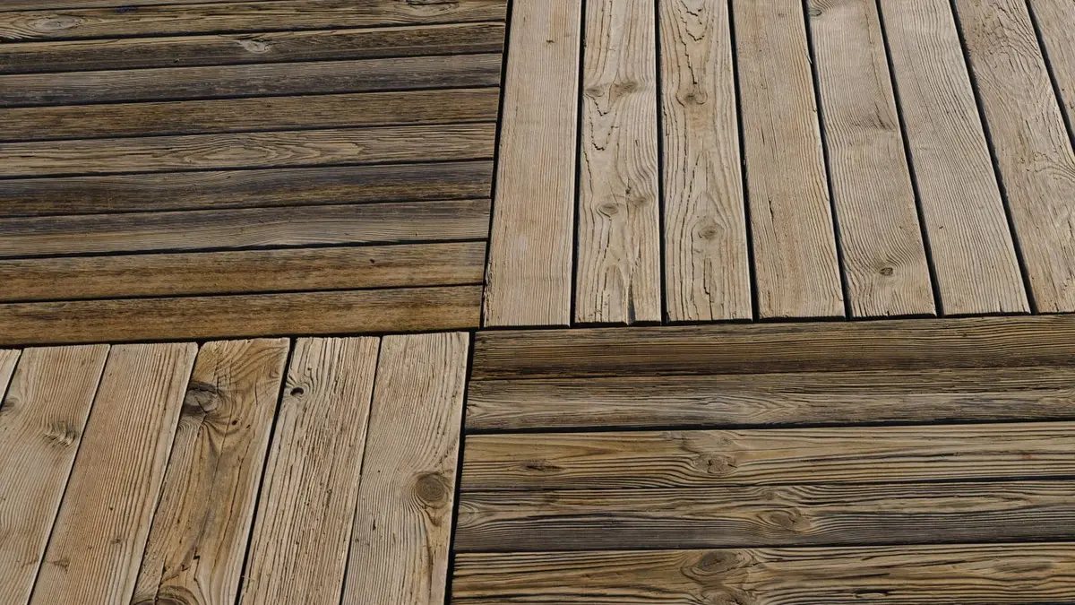 Lames de bois extérieur exposées aux intempéries, certaines grisées par les UV, d'autres encore dorées