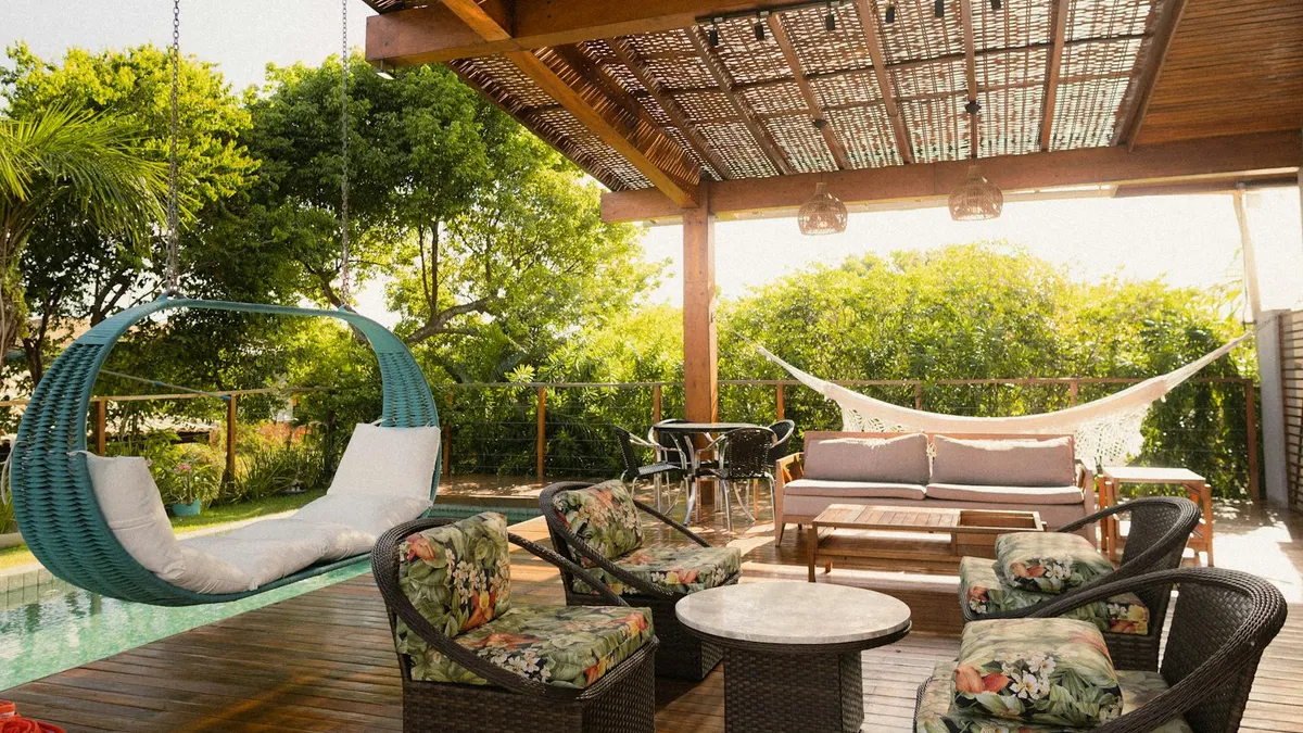 Pergola bois au-dessus d'une terrasse aménagée, avec salon de jardin